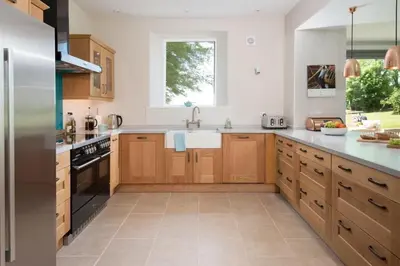 a kitchen with wooden cabinets and a sink at Beltie Lodge in Borgue