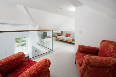 a living room with two chairs and a couch at Beltie Lodge in Borgue