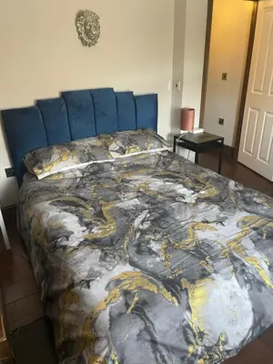 a bedroom with a bed with a painting on it at Flosh Cottage Lake District in Cleator