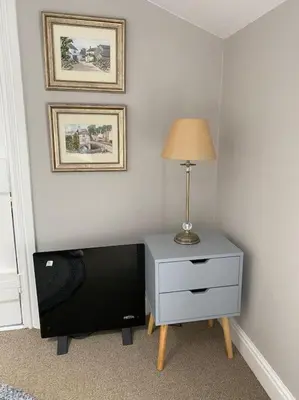a room with a nightstand and a lamp on a table at Kitty’s Place, Apartment, Eden Valley, Cumbria in Brampton