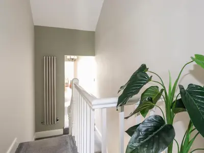 a hallway with a white staircase with a plant at Dovestones in Keswick