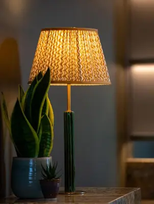 a lamp sitting on a table next to a plant at Fellpack House in Keswick