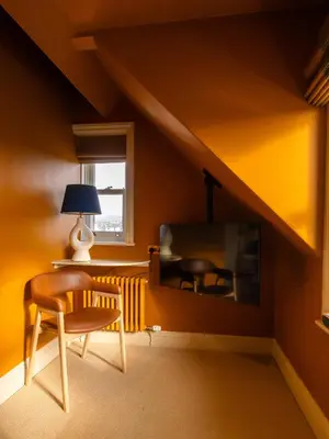 a room with a table and a chair and a television at Fellpack House in Keswick
