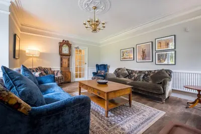 a living room with blue couches and a table at Swinside Lodge in Keswick
