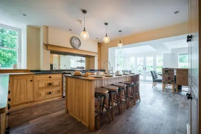 a kitchen with a large island with bar stools at Swinside Lodge in Keswick