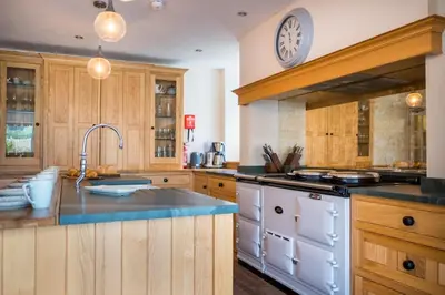 a kitchen with a sink and a clock on the wall at Swinside Lodge in Keswick