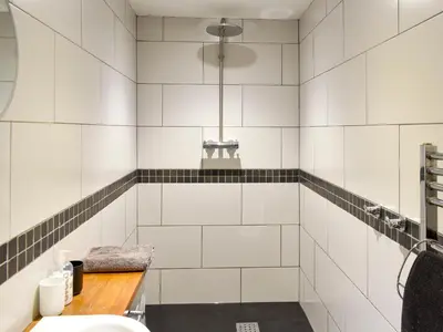 a bathroom with white tiled walls and a sink at Hilltoft Barn in Dockray