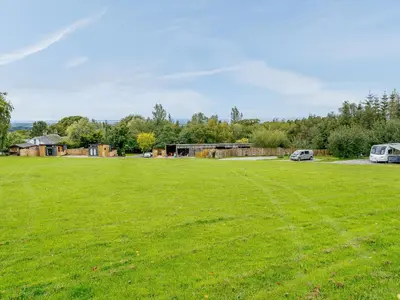 a large green field with a building in the background at Starling Lodge - Uk31071 in Westward