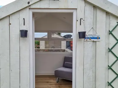 an open door into a shed with a chair at Southcroft Lodge in Whiting Bay