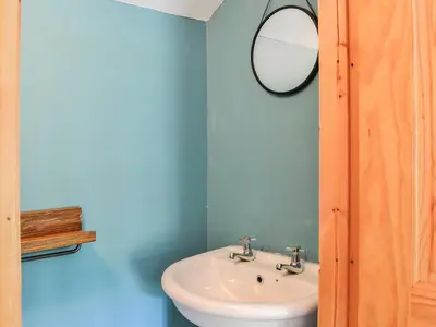 a bathroom with a white sink and a mirror at West Lanegate Farmhouse in Amisfield Town