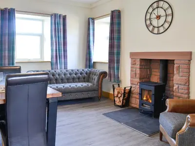 a living room with a couch and a fireplace at West Lanegate Farmhouse in Amisfield Town