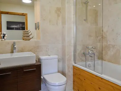 a bathroom with a toilet and a shower and a sink at Seaviews And Hot Tub At The Fairways - Uk39821 in Portpatrick