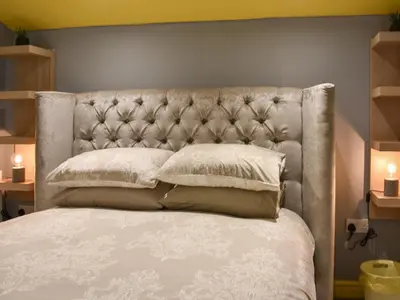 a bed with a headboard and pillows on it at Doddick Beck - Uk39153 in Threlkeld