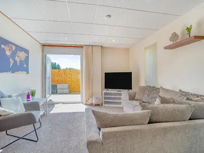 a living room with a couch and a flat screen tv at 1 Ladyknowe - Uk39970 in Moffat
