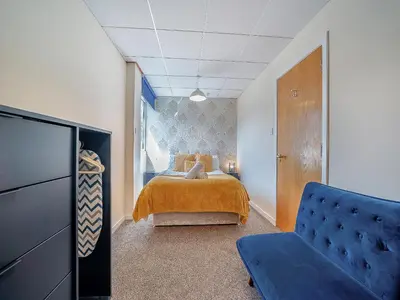 a bedroom with a bed and a blue couch at 1 Ladyknowe - Uk39970 in Moffat
