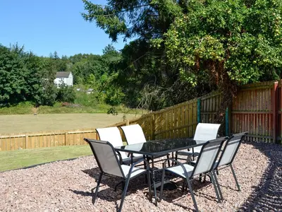 a patio table and chairs with a fence at Park Lane in Auldgirth