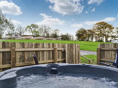 a hot tub in front of a wooden fence at Willow - Uk36374 in Westward