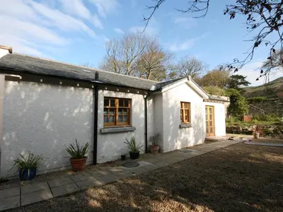 a white cottage with a driveway in front of it at Gardener's Cottage in Girvan