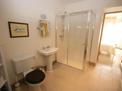 a bathroom with a shower and a toilet and a sink at Gardener's Cottage in Girvan