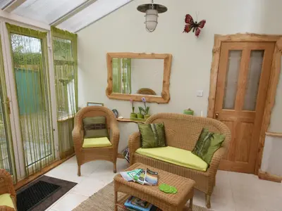 a living room with two chairs and a mirror at Gardener's Cottage in Girvan