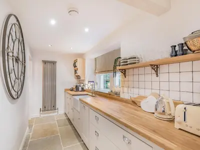 a kitchen with white cabinets and a counter top at Keepers Cottage in Durisdeer