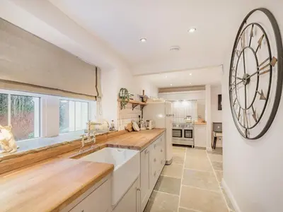 a kitchen with a large clock on the wall at Keepers Cottage in Durisdeer