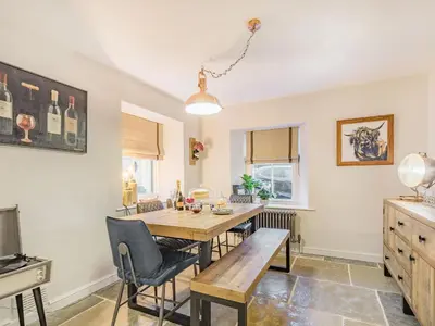 a kitchen with a wooden table and chairs at Keepers Cottage in Durisdeer