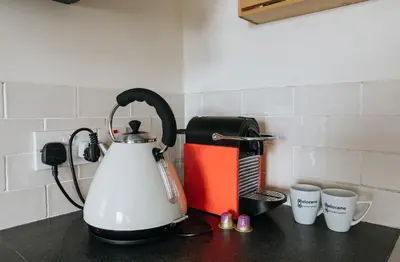 a tea kettle and cups on a kitchen counter at ELM HOUSE COTTAGE - 2 Bed Cottage in High Hesket on the edge of the Lake District, Cumbria in High Hesket