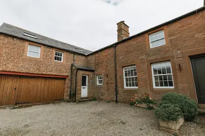a brick building with a garage and a gate at ELM HOUSE COTTAGE - 2 Bed Cottage in High Hesket on the edge of the Lake District, Cumbria in High Hesket