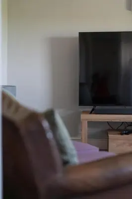 a living room with a couch and a television at Rose Cottage, Eden Valley, Cumbria in Cumwhitton