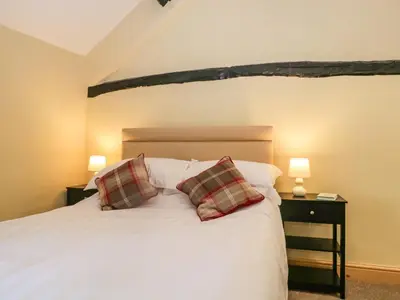 a bedroom with a white bed with two pillows at Fellside Cottage in Cockermouth