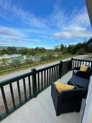 two chairs on a deck with a view of a field at Beautiful 3BR Holiday Home in Stunning Location - Pass the Keys in Moffat