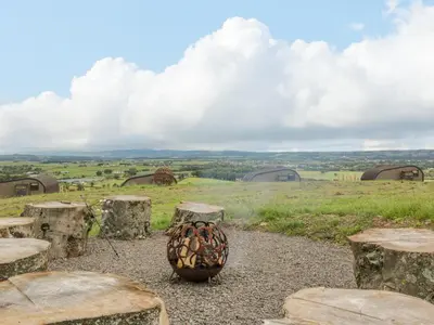 a vase sitting on top of a field with some rocks at Laird Lodge 4 in Lockerbie