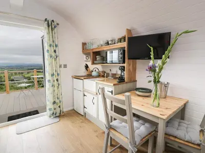 a kitchen with a table and a dining room with a balcony at Laird Lodge 3 in Lockerbie