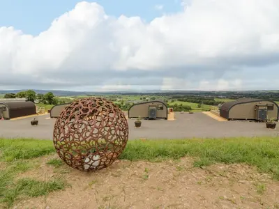 a sculpture of an egg sitting in the grass at Laird Lodge 5 in Lockerbie