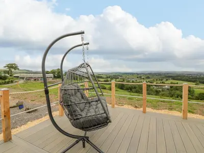 a bird cage on the deck of a house at Laird Lodge 2 in Lockerbie