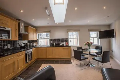 a large kitchen with a table and chairs in it at Waterfront Apartments in Douglas