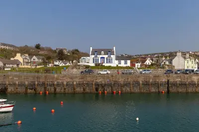 a boat sitting in the water near a harbor at The Knowe in Portpatrick