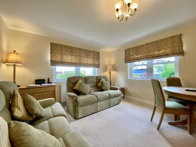 a living room with a couch and a table at 8 Howrahs Court, Keswick in Keswick
