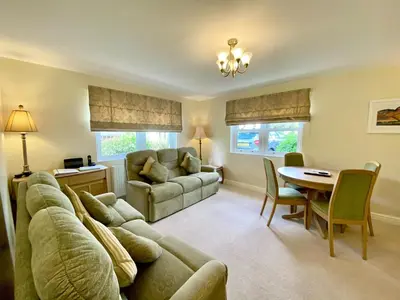a living room with a couch and a table at 8 Howrahs Court, Keswick in Keswick
