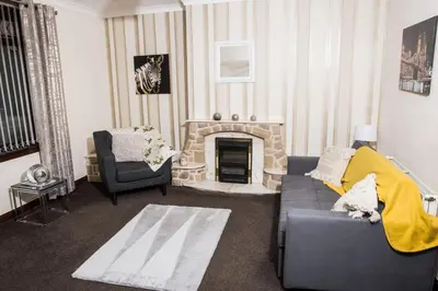 a living room with a couch and a fireplace at Rigside House in Douglas