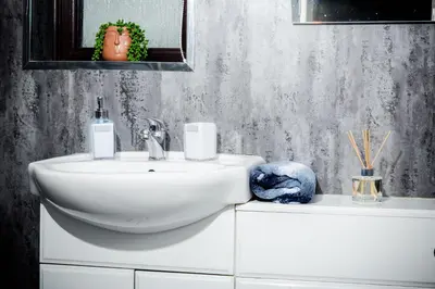 a bathroom with a white sink and a mirror at Rigside House in Douglas