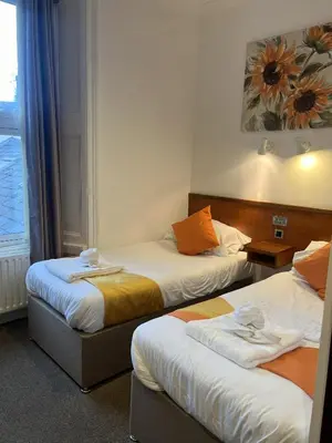 a hotel room with two beds and a window at Chase Hotel in Whitehaven