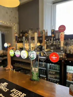 a bar with a bunch of stickers on a counter at Chase Hotel in Whitehaven