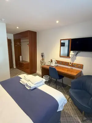 a hotel room with a bed and a desk at Chase Hotel in Whitehaven