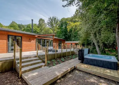 a house with a deck with a hot tub at Gadgirth Estate Lodges in Annbank