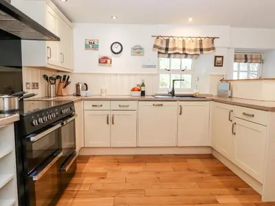 a kitchen with white cabinets and a stove top oven at Huntingstile Lodge in Ambleside