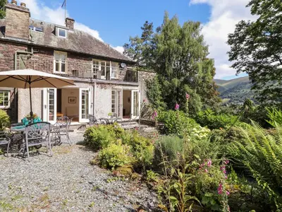 an exterior view of a house with a garden at Huntingstile Lodge in Ambleside