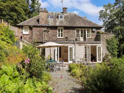 an old house with a garden in front of it at Huntingstile Lodge in Ambleside