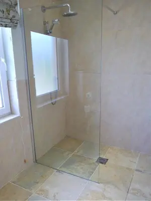 a shower stall with a glass shower door at Driftwood in Kippford